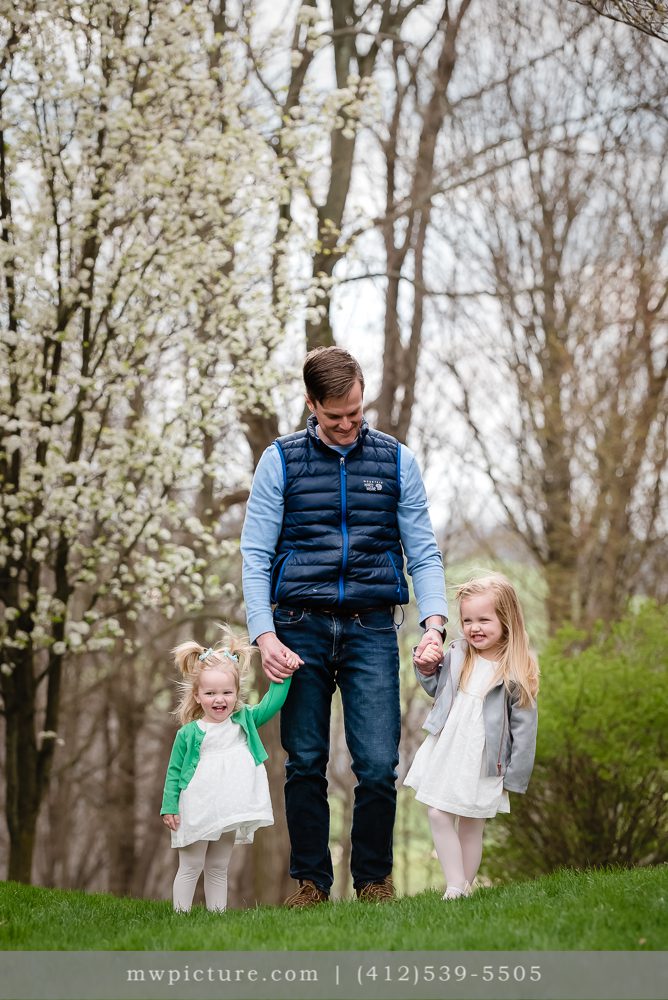 A Man Walking with His Two Daughters in the Park
