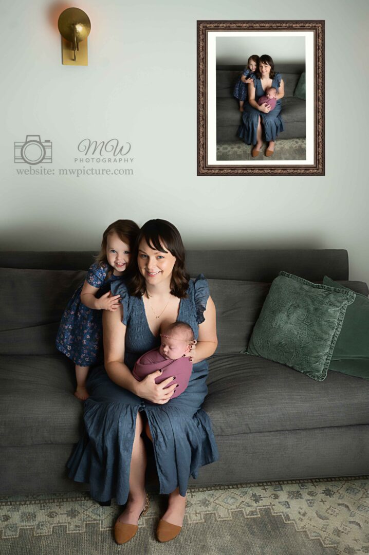 A woman holding her baby and sitting on the couch