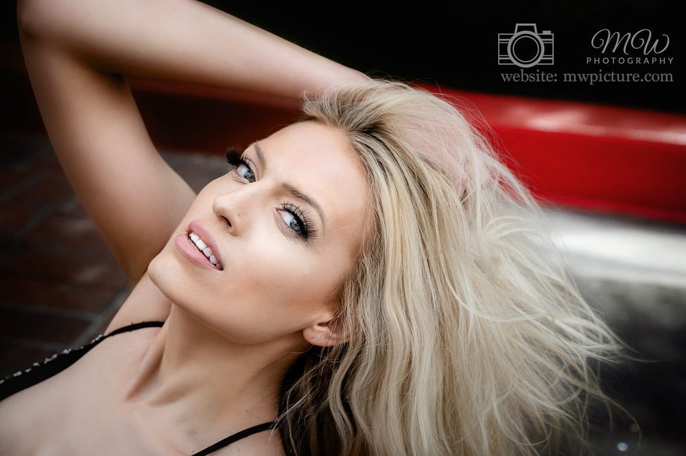 A woman with long blonde hair laying on the ground.